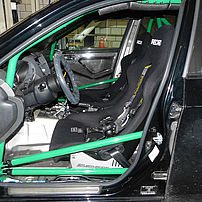 Individual vehicle with sports seats, harness seatbelts, a sports steering wheel and a roll cage